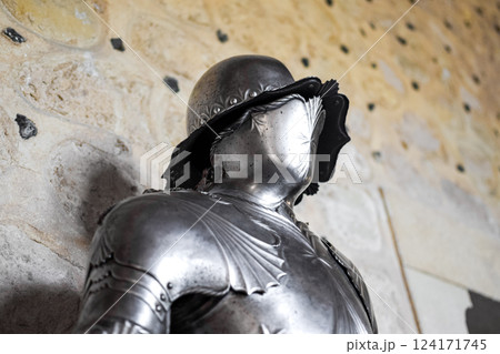 Close up view of medieval shiny armor and white stone wall in background. Close up view of medieval shiny armor and white stone wall in background. 124171745