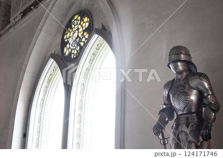 Front view Detailed Medieval shiny armor and gothic pointed arches in background Front view Detailed Medieval shiny armor and gothic pointed arches in background 124171746