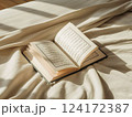 Serene Quran Reading Open Arabic Book on Soft White Bedsheets Serene Quran Reading Open Arabic Book on Soft White Bedsheets 124172387