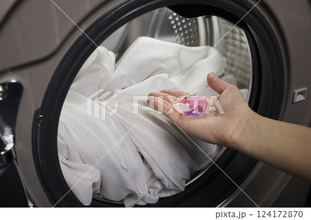Using Laundry Detergent Pods While Doing Laundry in the Washing Machine with Clothes Using Laundry Detergent Pods While Doing Laundry in the Washing Machine with Clothes 124172870