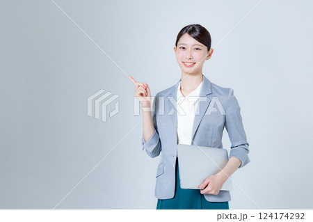 ノートパソコンを持って案内する女性ビジネスパーソン ノートパソコンを持って案内する女性ビジネスパーソン 124174292