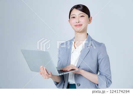 ノートパソコンを持って案内する女性ビジネスパーソン 124174294