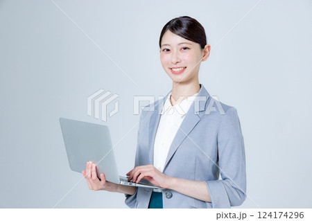 ノートパソコンを持って案内する女性ビジネスパーソン ノートパソコンを持って案内する女性ビジネスパーソン 124174296