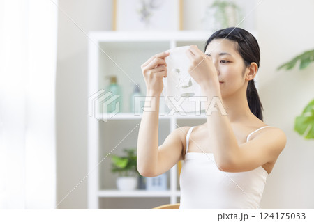 フェイスパックを手に取っている女性 フェイスパックを手に取っている女性 124175033