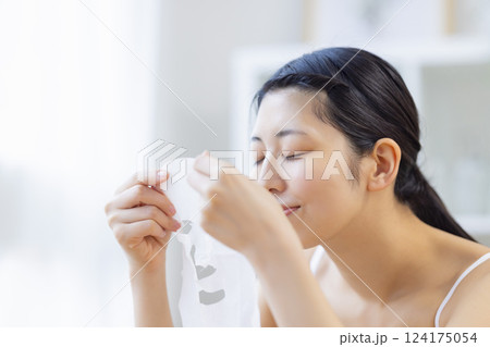 フェイスパックを手に取っている女性 124175054
