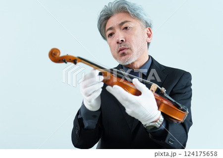 ヴァイオリンを点検する男性 124175658