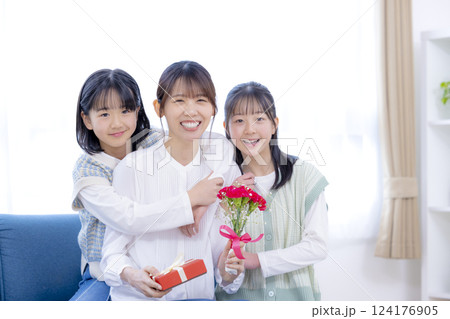 母の日にカーネーションを渡す女の子とママ 124176905