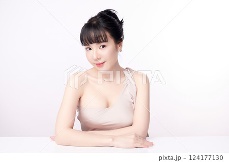A beautiful young Asian woman with clean, fresh skin against a white background. Skincare, facial treatment, cosmetology, beauty, and spa. An elegant portrait of an Asian woman. 124177130