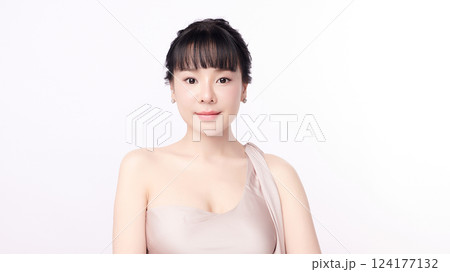 A beautiful young Asian woman with clean, fresh skin against a white background. Skincare, facial treatment, cosmetology, beauty, and spa. An elegant portrait of an Asian woman. 124177132