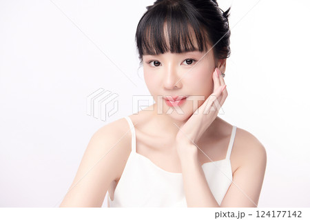 A beautiful young Asian woman with clean, fresh skin against a white background. Skincare, facial treatment, cosmetology, beauty, and spa. An elegant portrait of an Asian woman. 124177142