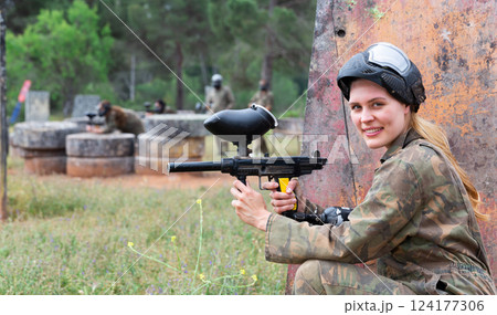 Portrait of girl in camouflage on paintball field 124177306
