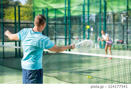 Man playing padel tennis match during training on court 124177341