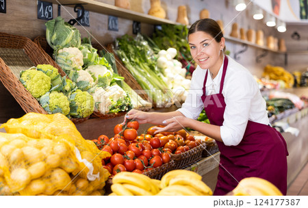 Young saleswoman offering tomatoes in eco products store 124177387