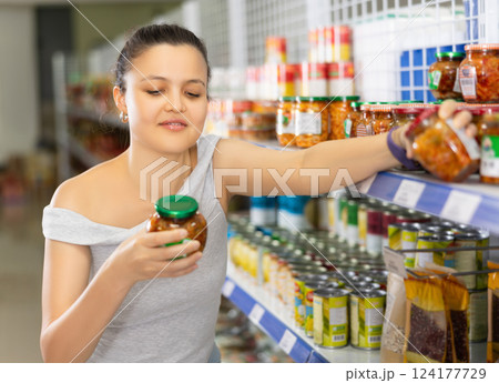 Positive asian girl buying chinese mustard in grocery store Positive asian girl buying chinese mustard in grocery store 124177729