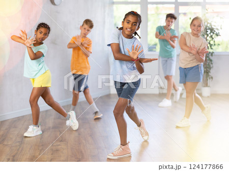 Positive smiling children studying modern style dance in class indoors 124177866