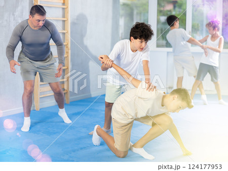 Teen boys practicing armlock in training bout during self defence course 124177953
