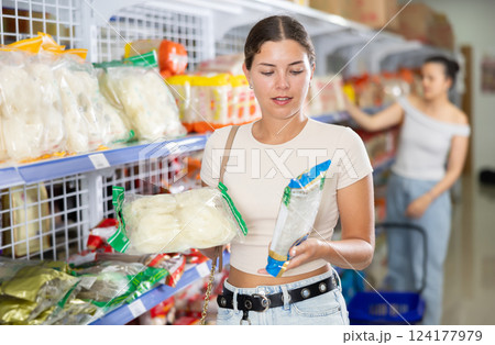 Female shopper choosing traditional Chinese noodles in supermarket Female shopper choosing traditional Chinese noodles in supermarket 124177979