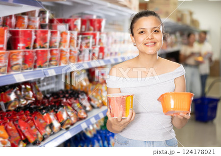 Asian female shopper choosing instant ramen in supermarket 124178021