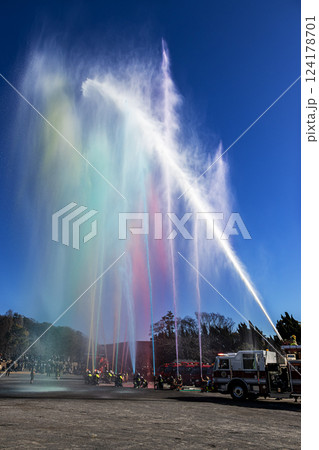 出初式の式典で消防隊員が青空に向けて、見せ場の一斉放水を披露する 出初式の式典で消防隊員が青空に向けて、見せ場の一斉放水を披露する 124178701