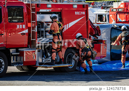出初式で消火活動の実演を披露するためにフル装備で消防車の装備を準備する消防隊員 124178738
