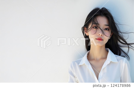 白い壁の前に立っている若い女性 124178986