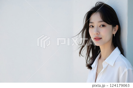白い壁の前に立っている若い女性 白い壁の前に立っている若い女性 124179063