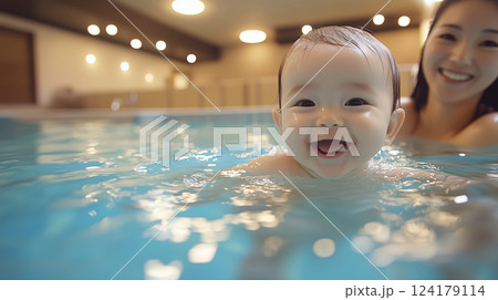 プールで笑顔の赤ちゃんと優しく見守る母親 124179114