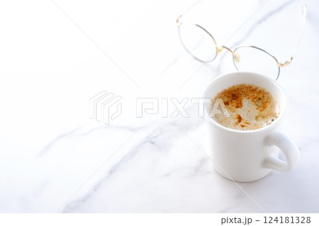 エスプレッソと牛乳を混ぜたカフェ・ラッテを飲みながらリラックスしているイメージ エスプレッソと牛乳を混ぜたカフェ・ラッテを飲みながらリラックスしているイメージ 124181328