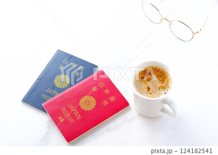 パスポート(10年用赤色と5年用紺色)を用意して、コーヒーを飲みながら海外旅行を計画しているイメージ パスポート(10年用赤色と5年用紺色)を用意して、コーヒーを飲みながら海外旅行を計画しているイメージ 124182541