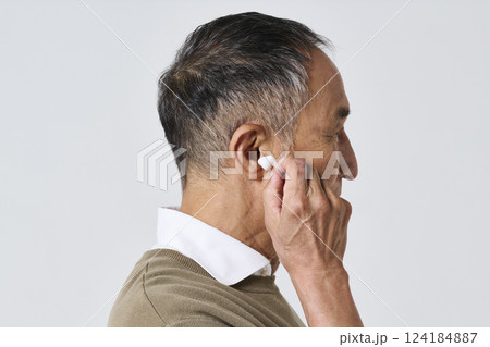 ワイヤレスイヤホンを使う私服姿のシニア男性 124184887