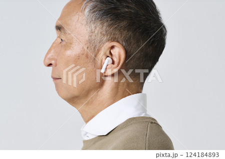 ワイヤレスイヤホンを使う私服姿のシニア男性 124184893
