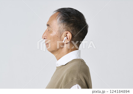 ワイヤレスイヤホンを使う私服姿のシニア男性 124184894