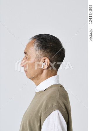 ワイヤレスイヤホンを使う私服姿のシニア男性 124184895
