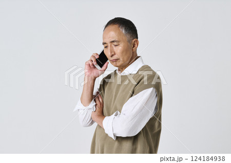 スマートフォンで通話をする暗い表情のシニア男性 スマートフォンで通話をする暗い表情のシニア男性 124184938