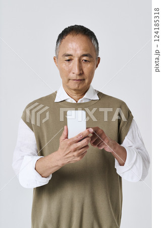 スマートフォンを使う私服姿のシニア男性 124185318