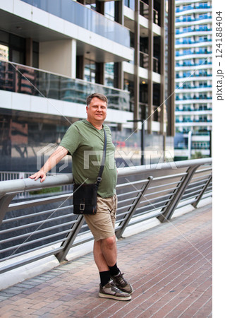 A blond man with a dense build in summer clothes on a city street A blond man with a dense build in summer clothes on a city street 124188404