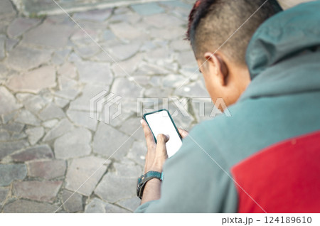 Close up of person messaging with his smartphone outdoors. Close up of a man texting with cell phone Close up of person messaging with his smartphone outdoors. Close up of a man texting with cell phone 124189610