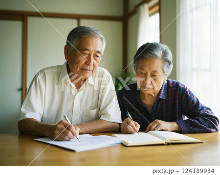 高齢の夫婦が書類を書いている 124189934