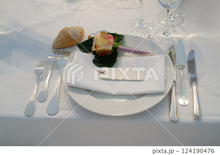 Elegant Table Setting With Floral Decoration and Silver Cutlery on White Linen 124190476