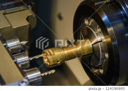 Close up scene multi-tasking CNC lathe machine swiss type hole drilling process the brass coupling parts. Close up scene multi-tasking CNC lathe machine swiss type hole drilling process the brass coupling parts. 124190993