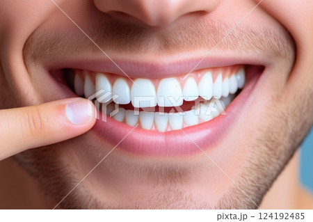Happy man pointing at his clean white teeth, studio shot 124192485