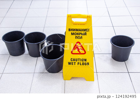 Caution Wet Floor yellow warning sign on a tile floor 124192495