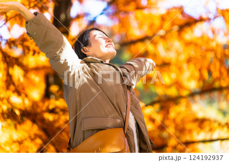 紅葉を楽しみながらストレッチをする女性 ライフスタイルイメージ 紅葉を楽しみながらストレッチをする女性 ライフスタイルイメージ 124192937