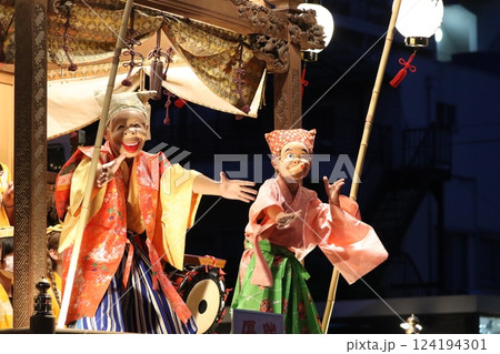 お神輿に乗るひょっとこ面と笑面の人物 お神輿に乗るひょっとこ面と笑面の人物 124194301