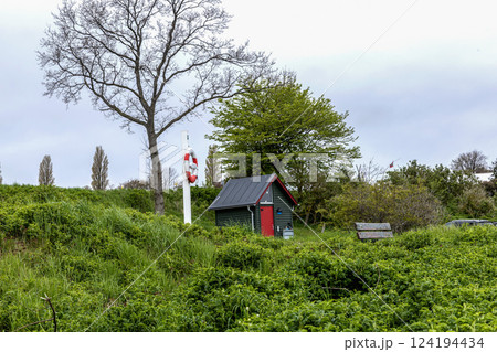Lifebuoy and a small house on the seashore 124194434