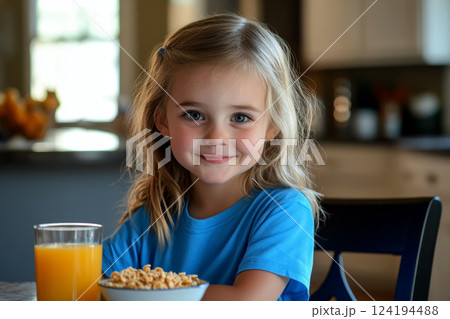 girl eating cereal and orange juice having breakfast. 124194488
