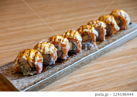 Burned Salmon Sushi roll with cheese served on plate Burned Salmon Sushi roll with cheese served on plate 124196444