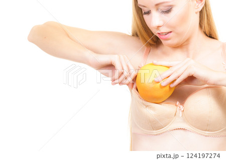 Woman small boobs puts big fruit in her bra Woman small boobs puts big fruit in her bra 124197274