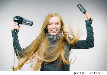 Girl holds hair accessories, styling hair 124197299