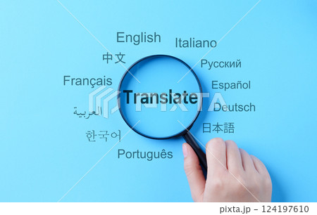Translation and Multilingual Communication Concept. A magnifying glass highlights the word "Translate," surrounded by names of multiple languages, multilingual translation, and global communication. 124197610